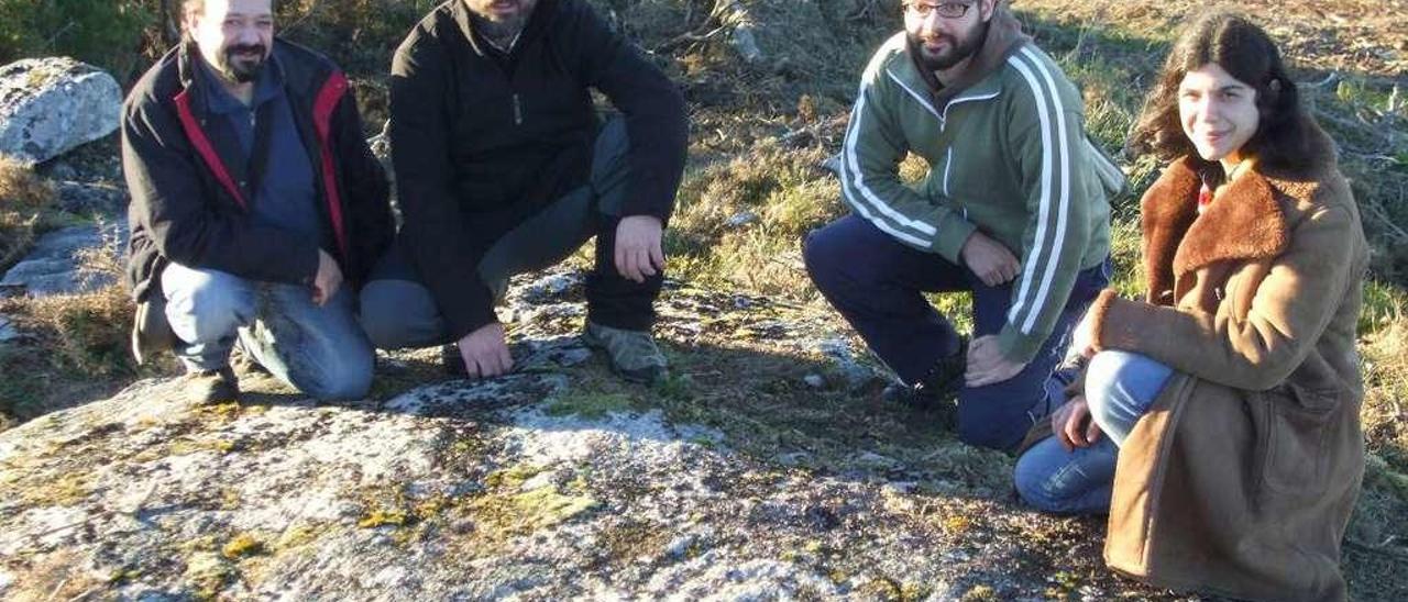 Membros de Capitán Gosende a carón do petróglifo de Carballás (Cerdedo).