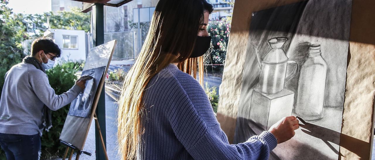 Estudiantes de ESO en clase de Música bajo la pinada y alumnos de Bachillerato en clase de Dibujo.