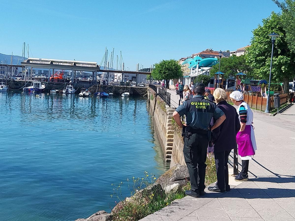 El Seprona de la Guardia Civil y comerciantes de la plaza de abastos de Cangas en el lugar del vertido de esta mañana.
