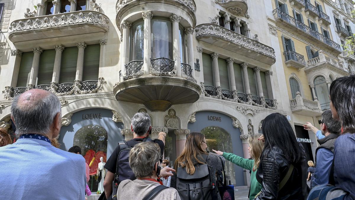 Turistas en el lateral del paseo de Gracia frente a la Casa Lleó Morera