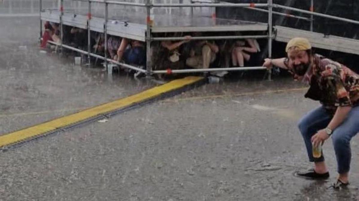 La gente se refugia bajo el escenario.