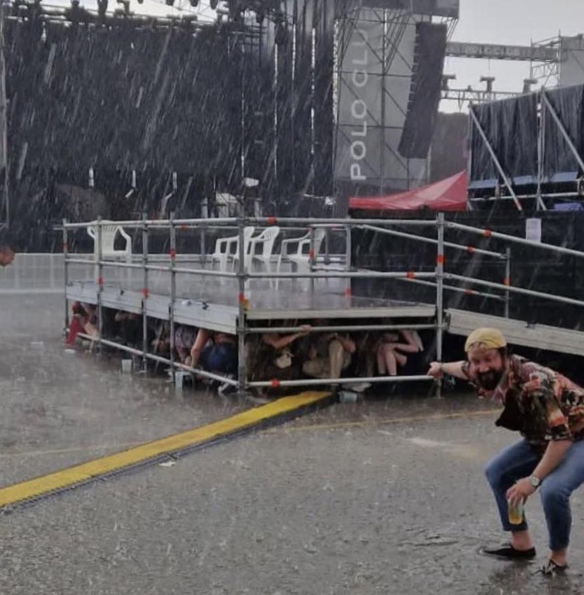 La gente se refugia bajo el escenario.