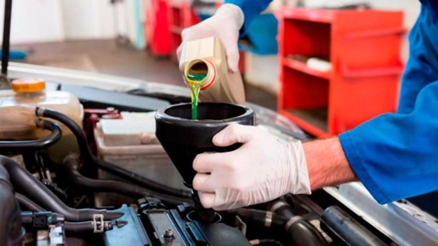 Imagen de archivo del cambio de aceite del motor de un vehículo en un taller de mecánica, la actividad que más lubricantes usados genera