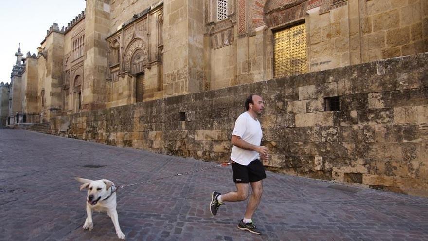 Una persona corriendo con su perro junto a la Mezquita-Catedral.