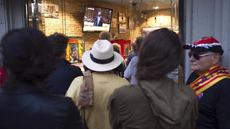 Un grupo de ciudadanos ven expectantes el discurso de Puigdemont en un bar de Cataluña.