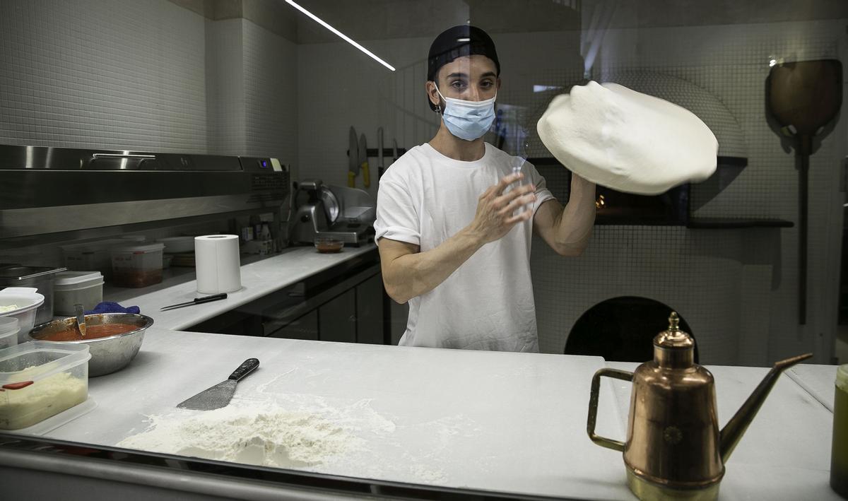 Un pizzero maneja la masa de la pizzería Nap.