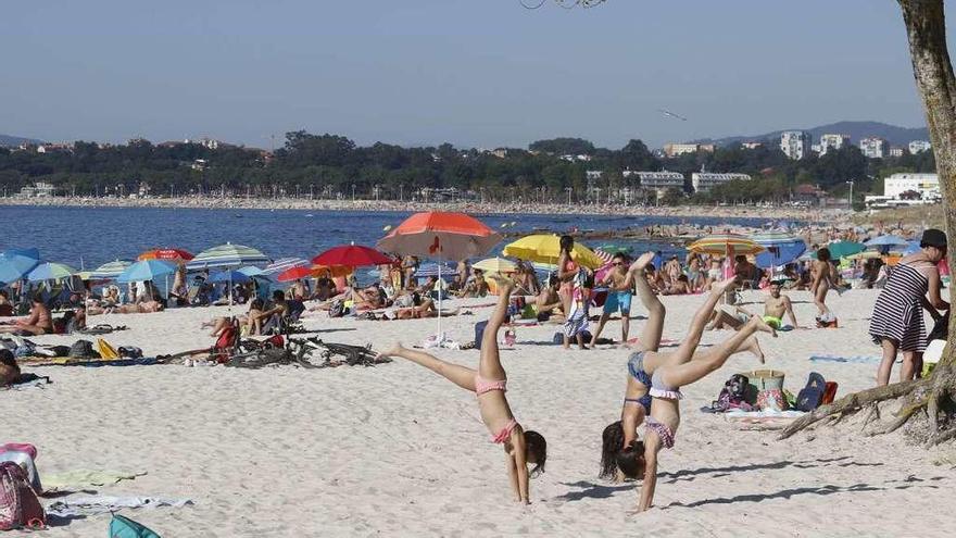 Usuarios de la playa viguesa de O Vao disfrutando ayer de las altas temperaturas. // Alba Villar