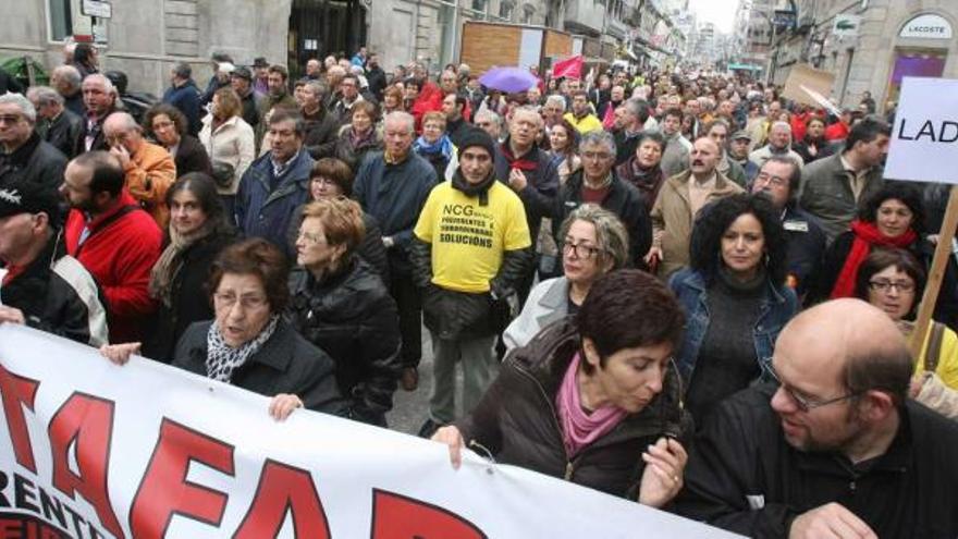 Un momento de la manifestación de los titulares de preferentes y subordinadas, ayer, a su paso por la calle Príncipe, en Vigo.  // J. de Arcos