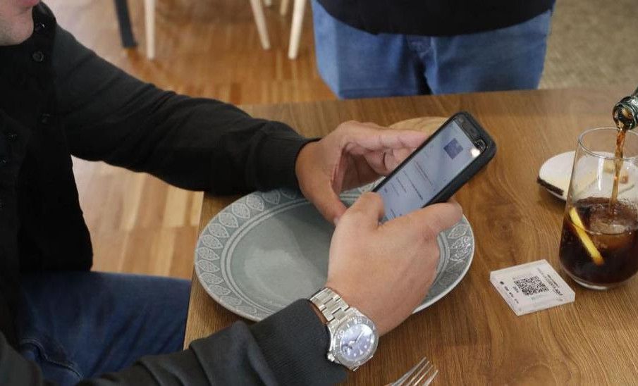 Un camarero sirve una consumición a un cliente en un restaurante de Vigo.