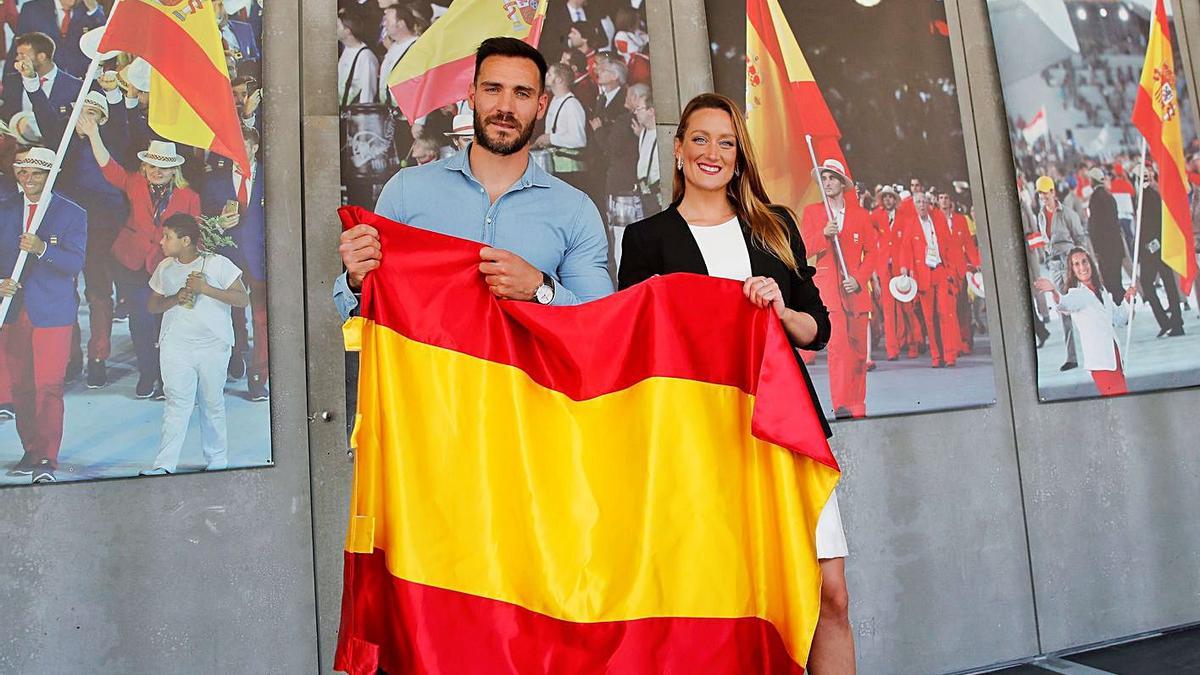 Craviotto y Mireia Belmonte posaban ayer en la sede del COE con la bandera de España. | COE