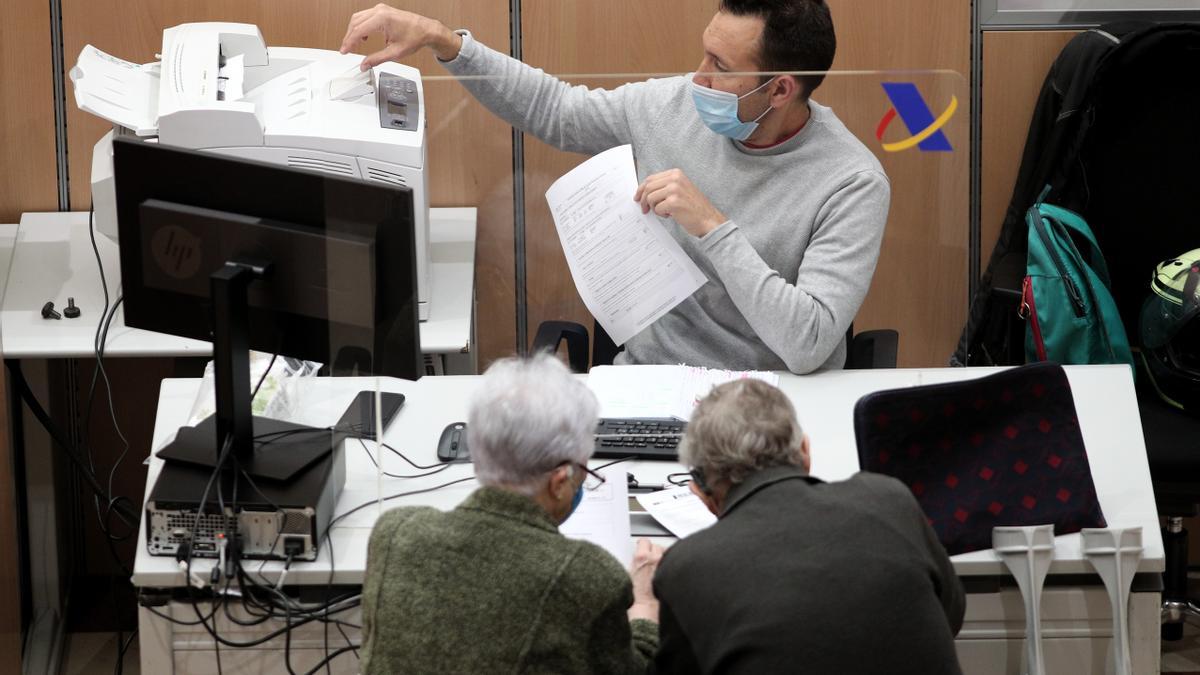 Dos personas presenta su declaración de la renta en la Agencia Tributaria.