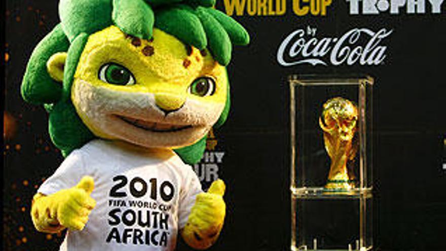 La mascota del Mundial, el leopardo &#039;Zakumi&#039;, junto al Trofeo de la Copa Mundial