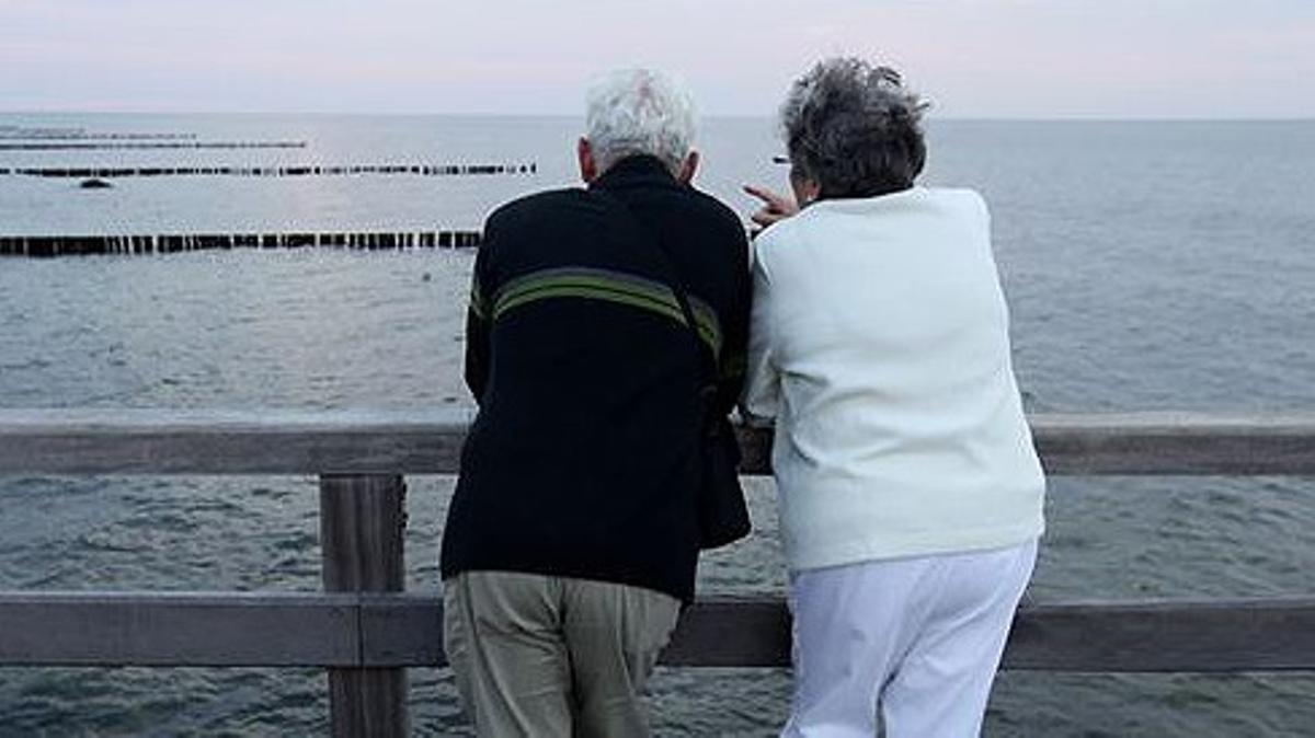 Una pareja de jubilados observa el mar desde un mirador. Una pareja de jubilados observa el mar desde un mirador.
