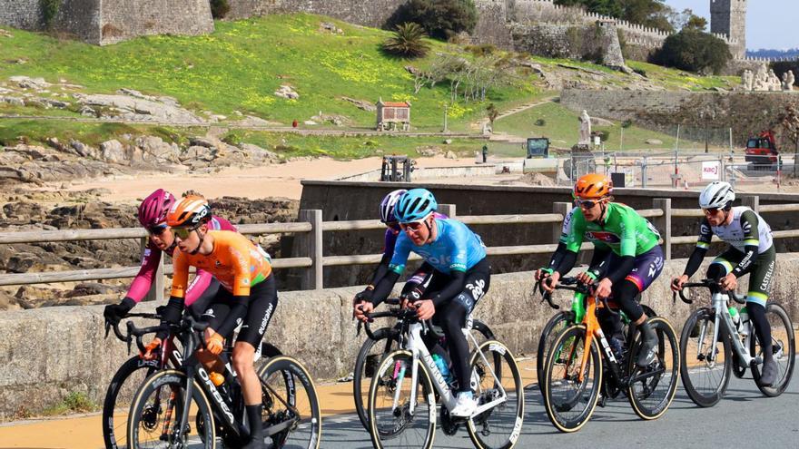 Los ciclistas fugados pasan por delante del Parador de Baiona con el pelotón muy cerca de ellos. marta g. brea