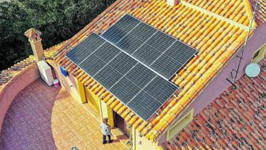 Dos operarios de Holaluz instalando placas  solares en el tejado de una vivienda | ‘activos’