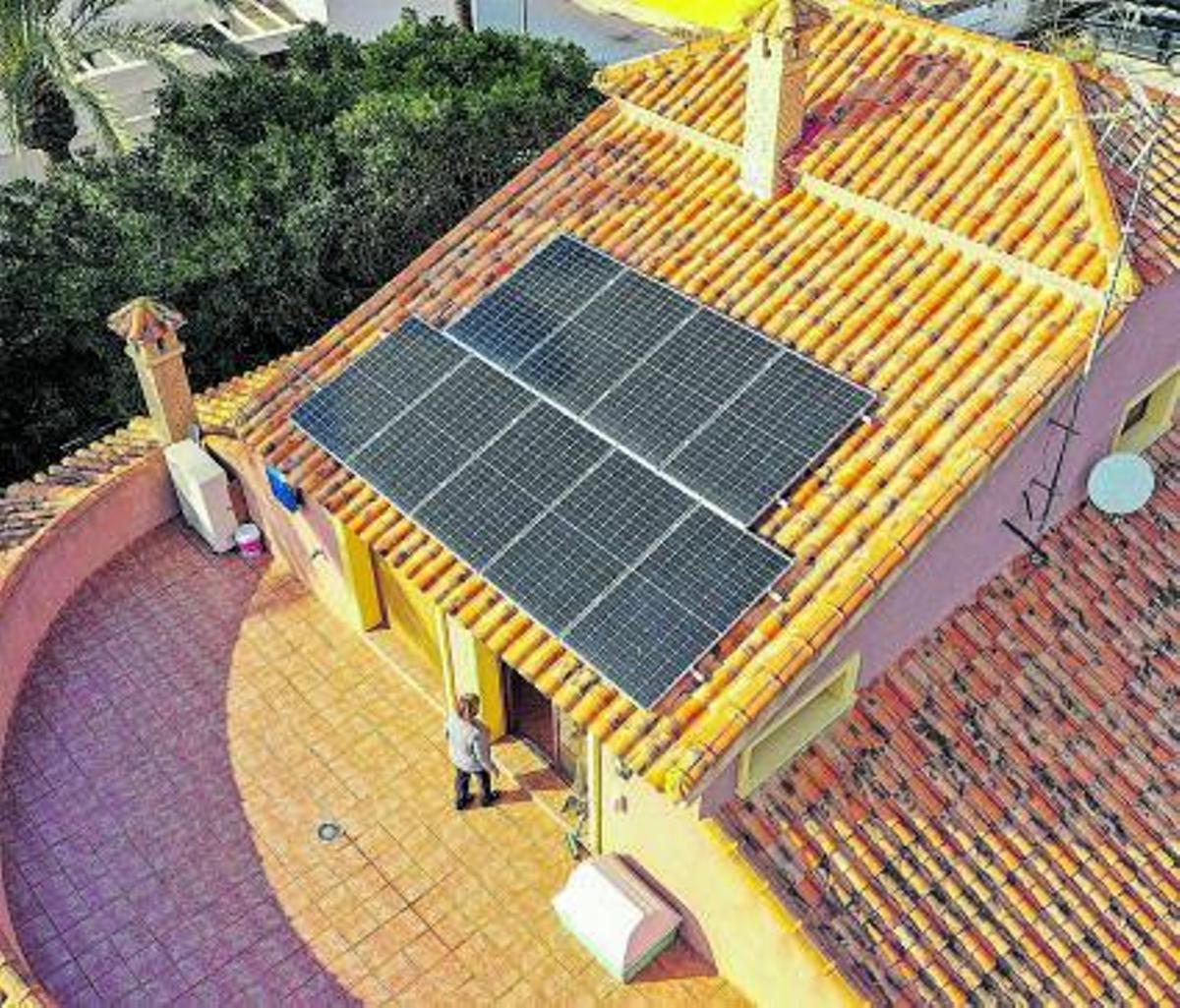 Dos operarios de Holaluz instalando placas  solares en el tejado de una vivienda | ‘activos’