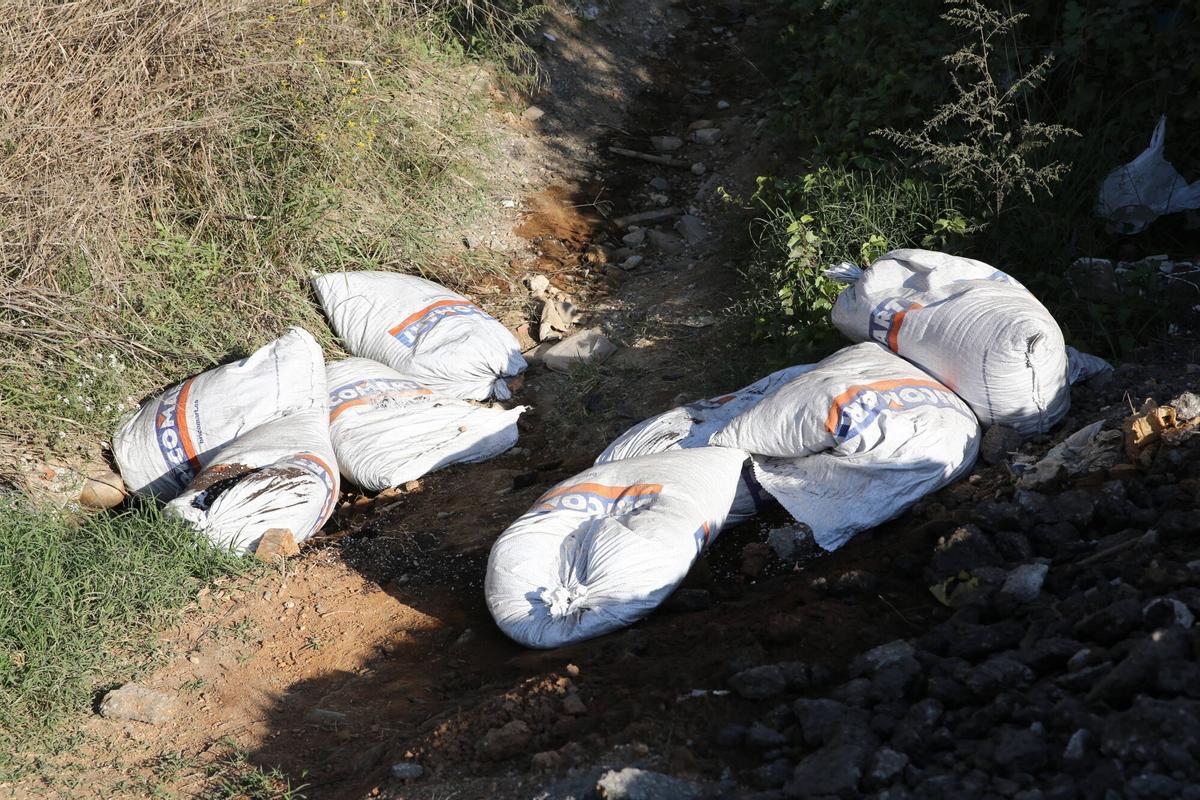 Sacos de obra abandonados en el medio natural, dentro del término municipal de Montcada i Reixac, en el mes de octubre