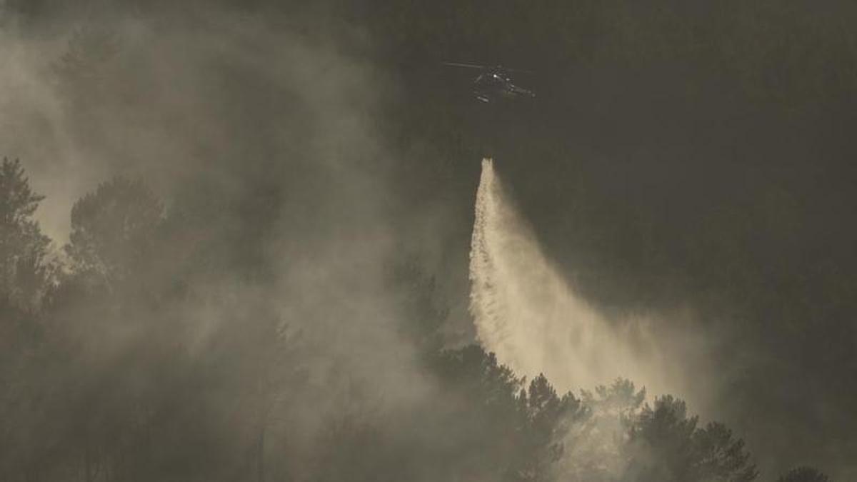 Un helicóptero realiza una descarga de agua sobre las llamas en Crecente.
