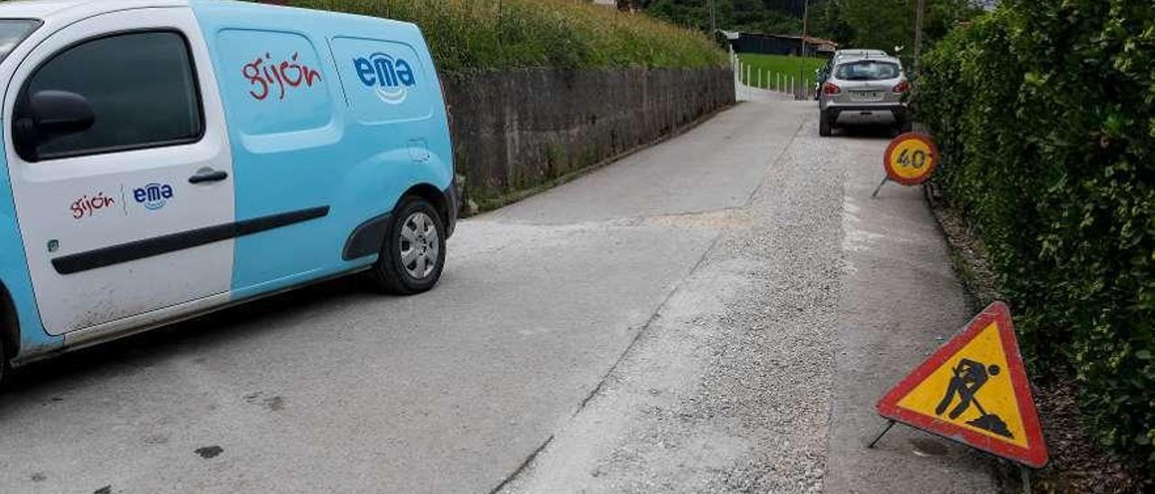 Un vehículo de la Empresa Municipal de Aguas, en Lavandera, junto a unas señalizaciones de obra.