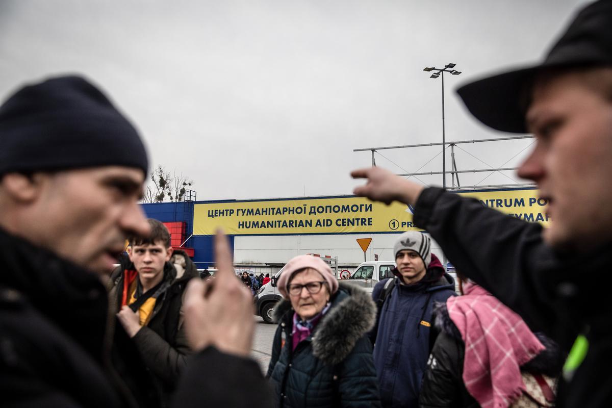Policías asisten a refugiados procedentes de Ucrania en el centro de acogida temporal de Przemysl, en Polonia.