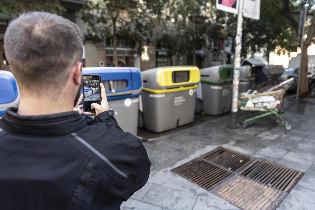 Un inspector del servicio de limpieza del Ayuntamiento de Barcelona controla mediante una 'app' los contenedores en la calle Valldonzella.