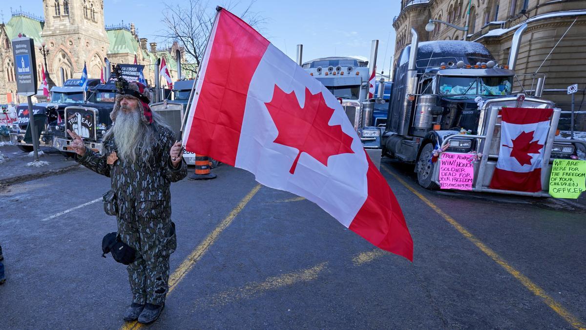 OTTAWA (CANADÁ), 07/02/2022.- Una persona ondea una bandera de Canadá durante una manifestación y una sentada, tras una protesta de 10 días de los camioneros por las restricciones de Covid-19 que ha paralizado el centro de Ottawa (Canadá). EFE/ Andre Pichette