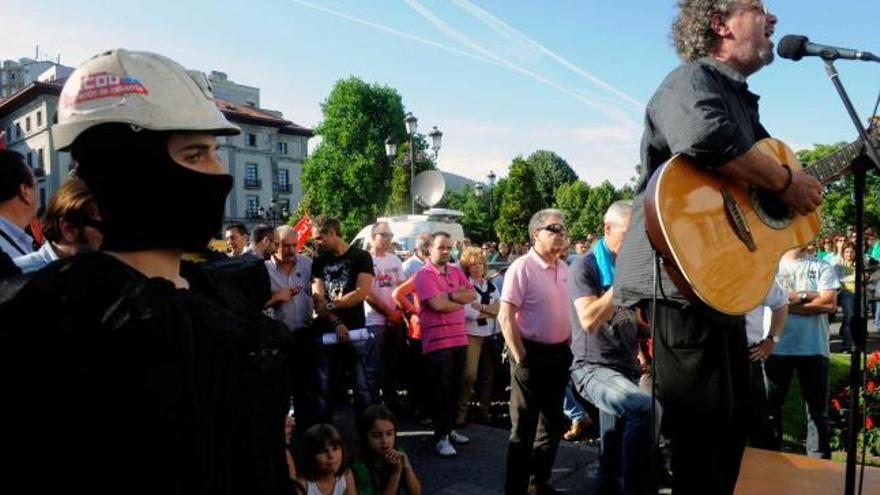 carbonman, entre profesores. Al igual que los docentes tienen a su Superpública, los mineros tienen a Carbonman. El personaje reivindicativo, disfrazado de piedra de hulla, a la izquierda de la foto, escucha junto a los asistentes a la manifestación de ayer a Manolo el de «Nuberu». | nacho orejas