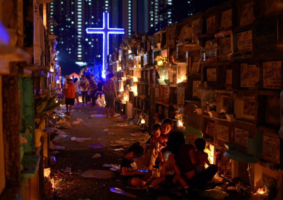 Filipino families visit the graves of their ...