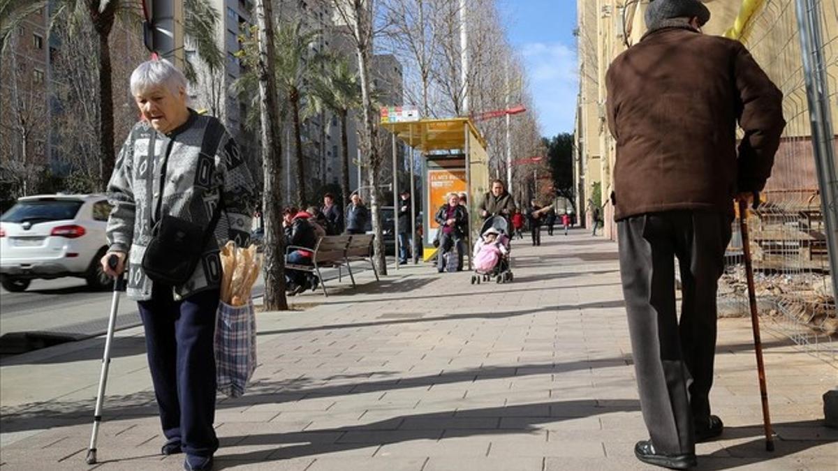 Dos ancianos caminan por la Guineueta, en Barcelona.