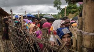 Los refugiados rohingya hacen cola en un centro de distribución de ayuda humanitaria cerca de Cox s Bazar