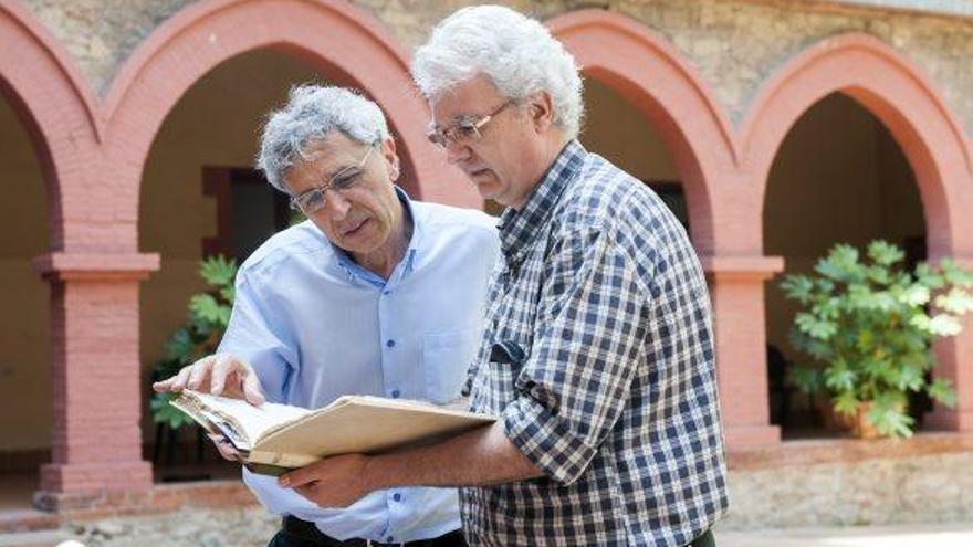 Joaquim Aloy i Marc Torras fullejant els documents al pati interior del convent de Santa Clara de Manresa