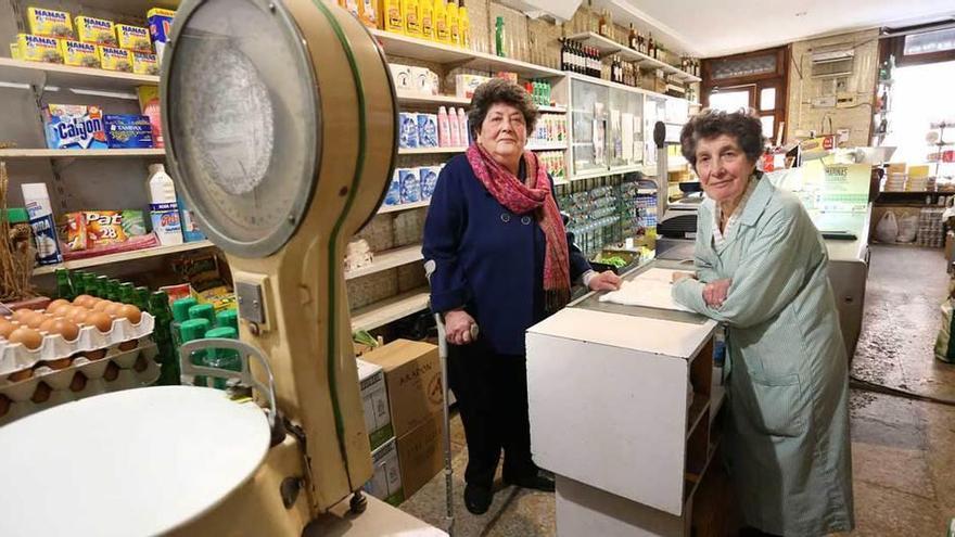 Fina Clemente (a la derecha) y su hermana Elvia, ayer, en su tienda de ultramarinos de la calle Mon.