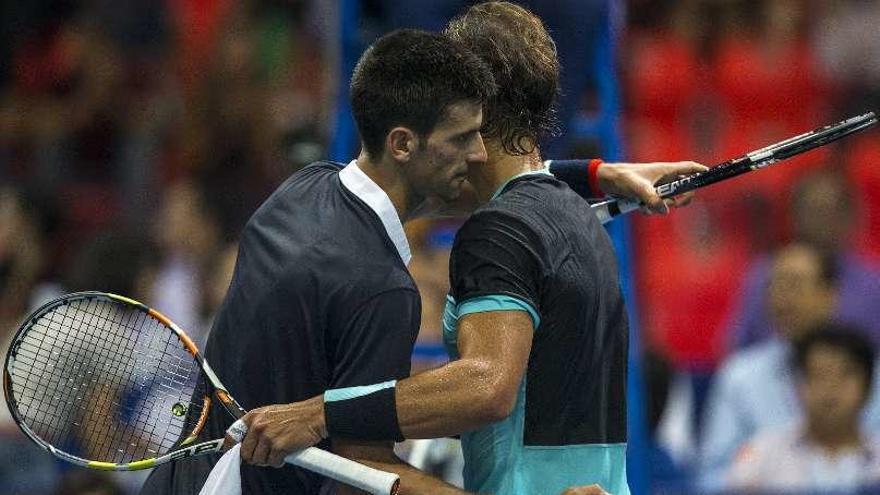 Djokovic y Nadal se abrazan al acabar el partido de exhibición.