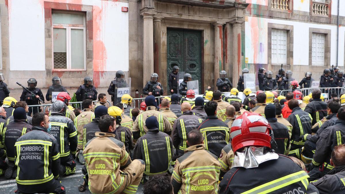 Sentada de los bomberos ante la Diputación, con la fachada ensuciada con pintura.