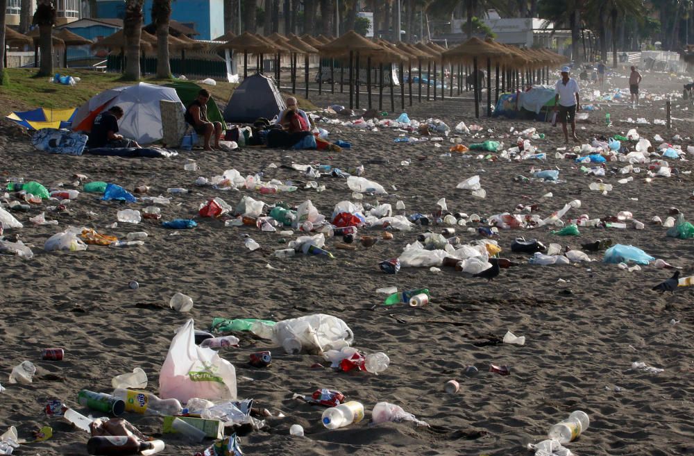 Los operarios de los servicios de limpieza trabajan para dejar la playa en óptimas condiciones tras una larga noche de fiesta en la arena