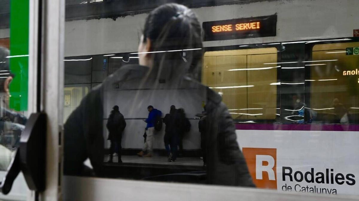 Usuarios de los trenes de Rodalies esperan las llegada de sus convoys en la estación de Sants en un servicio que funciona con retrasos pero no está interrumpido. Fotografía de Jordi Cotrina
