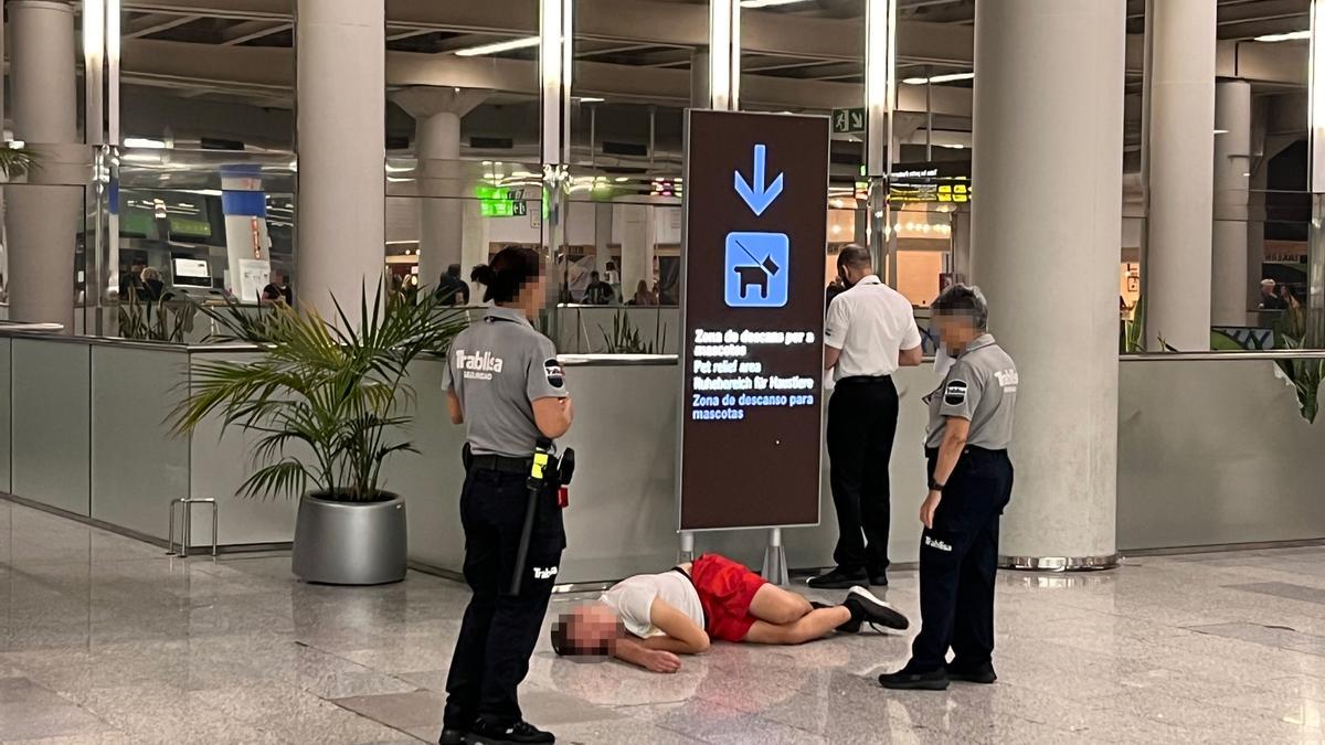 Ein betrunkener Tourist liegt auf dem Boden des Flughafenterminals von Palma.