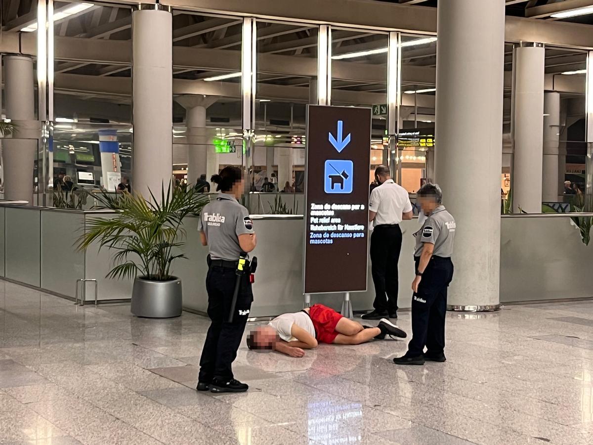 Un turista tirado en el suelo de la terminal del aeropuerto de Palma.