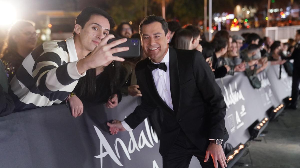 Juanma Moreno a su llegada a la gala de los Goya se hace un selfi con un joven del público.