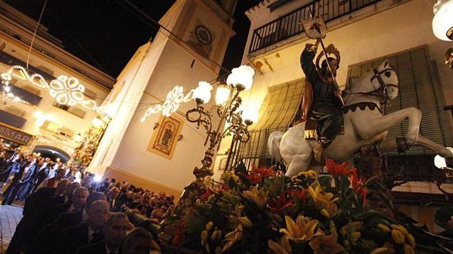 La imagen de San Jaime Apóstol baja la calle Mayor tras salir de la iglesia para iniciar la procesión, a hombros de los Costalers de Sant Jaume