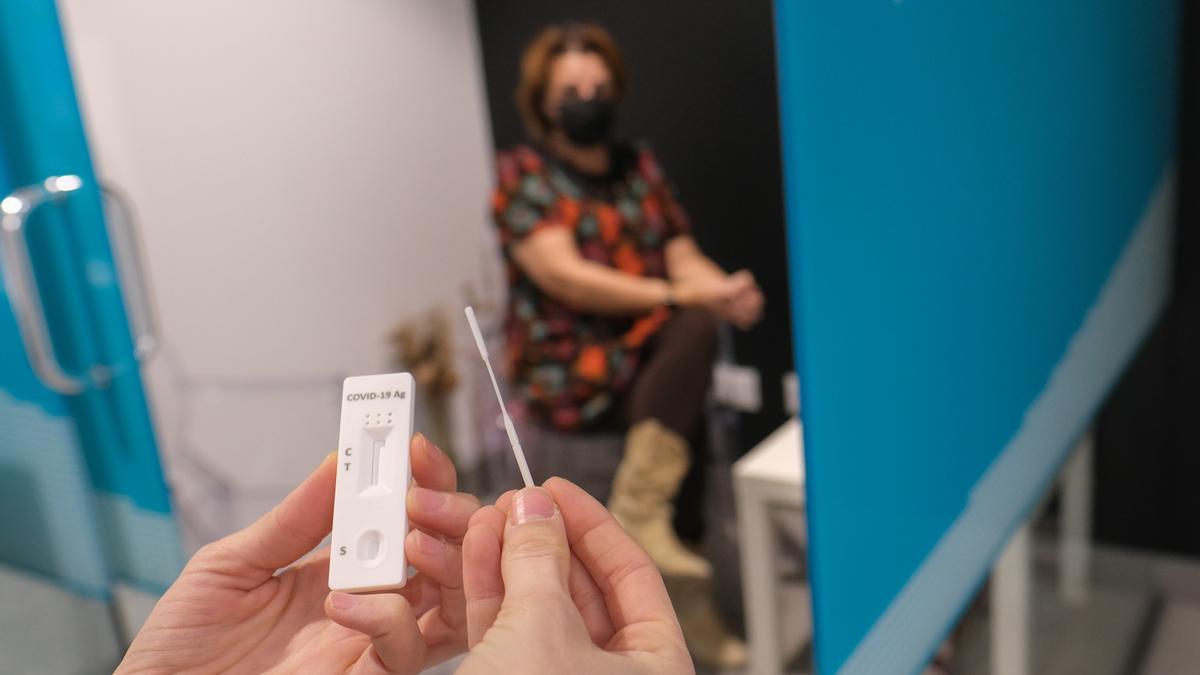 Una mujer esperando a realizarse un test de antígenos covid en una farmacia