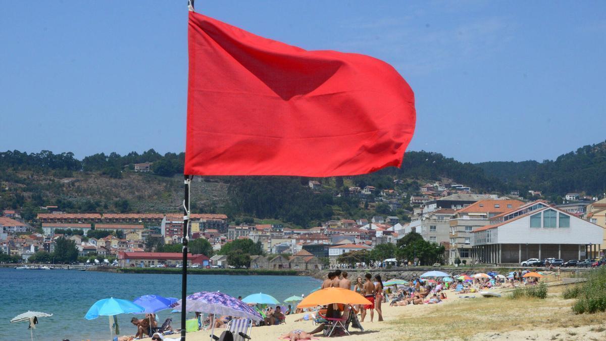 Una playa con la bandera roja.