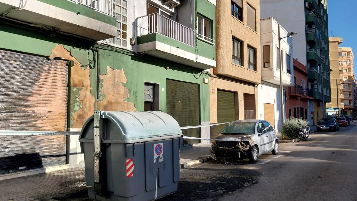 Un coche destruido por el fuego, ante el edificio donde se produjo el incendio.