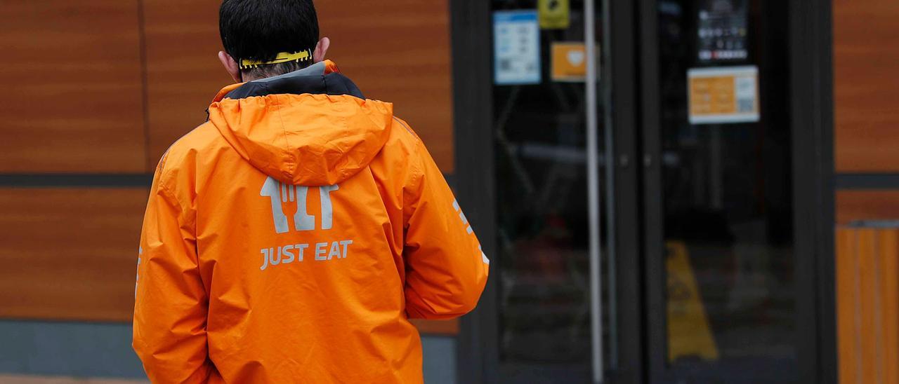 Un repartidor de comida a la espera, en la puerta de un establecimiento de comida rápida