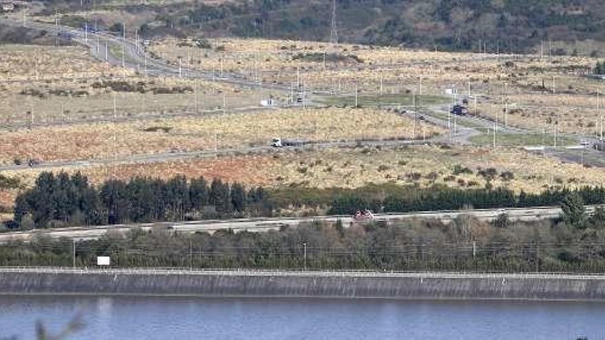 Viales y parcelas de la Zalia -con restos de plumeros de la Pampa- a continuación del pantano de San Andrés de los Tacones y la autopista &quot;Y&quot;, que están en primer término.