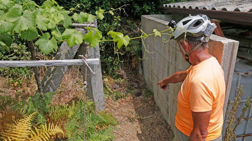 Un vecino muestra el lugar donde una mujer ha sido hallada muerta con una herida de arma blanca, en la localidad coruñesa de A Pobra do Caramiñal.