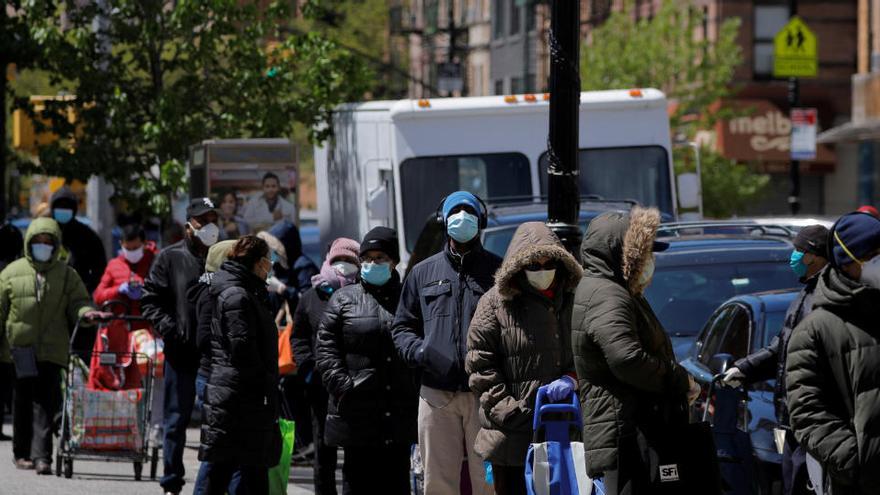 Varias personas hacen cola para recoger comida en Nueva York.