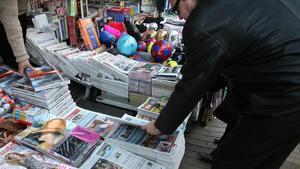 Un hombre compra un periódico en un quiosco de Barcelona.
