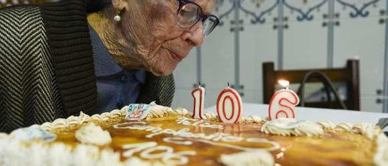 Carmen Suárez soplando las velas de la tarta.