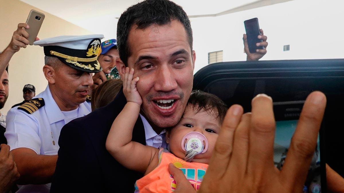 Guaidó vuelve a Venezuela bajo la amenaza de ser detenido por orden de Maduro. En la foto, Guaidó se hace una foto con un niño al salir de su hotel en Salinas, Ecuador.